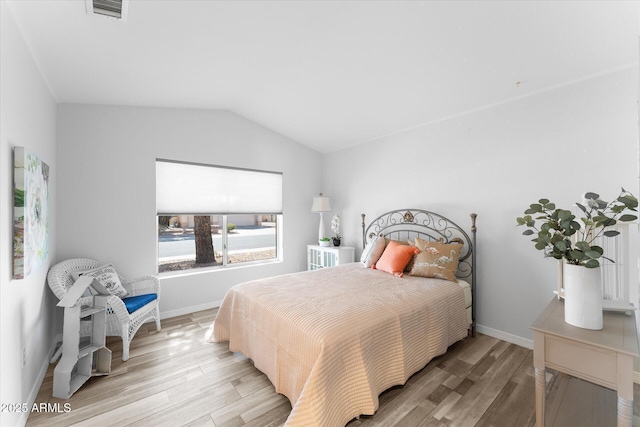 bedroom featuring lofted ceiling, light wood-style flooring, baseboards, and visible vents