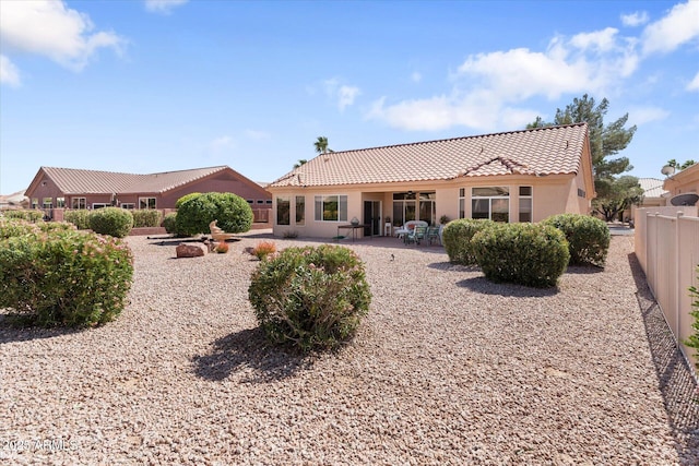 back of house with a patio, a tiled roof, fence, and stucco siding