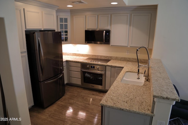 5720 S 21st Ter, Phoenix, AZ 85040 - kitchen with appliances with stainless steel finishes, a sink, light stone counters, dark wood-type flooring, and recessed lighting