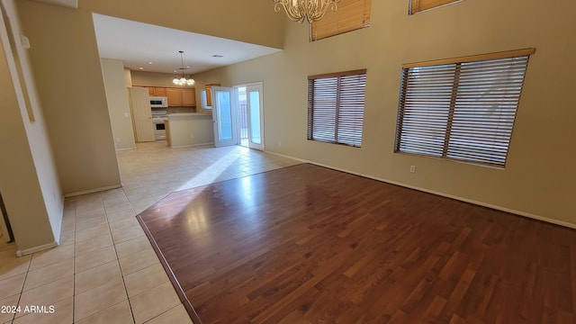 unfurnished living room with light tile patterned flooring and a chandelier