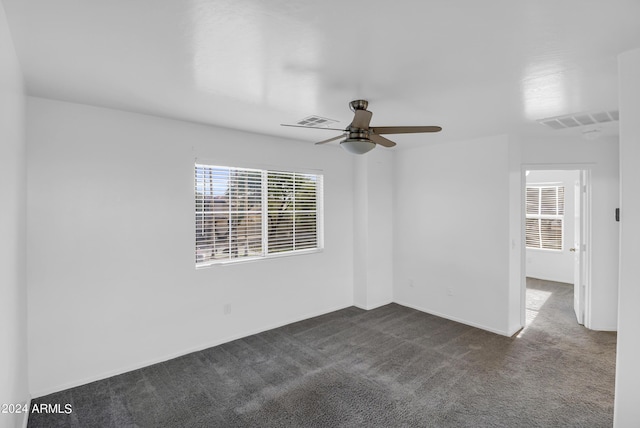 carpeted spare room featuring ceiling fan