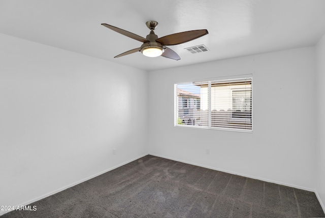 empty room featuring dark colored carpet and ceiling fan