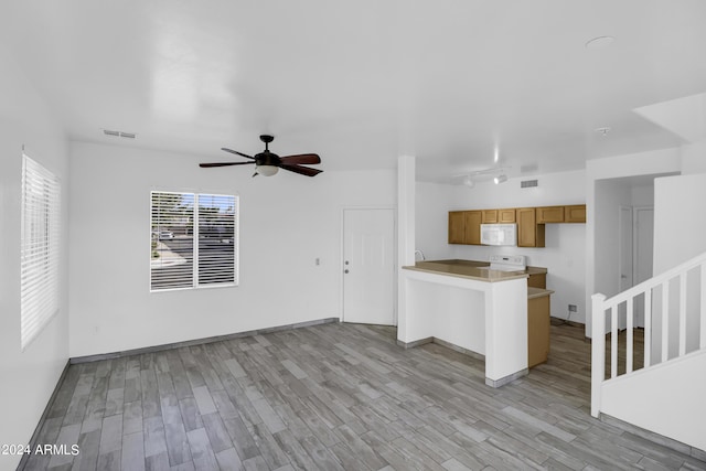 unfurnished living room with ceiling fan and light wood-type flooring