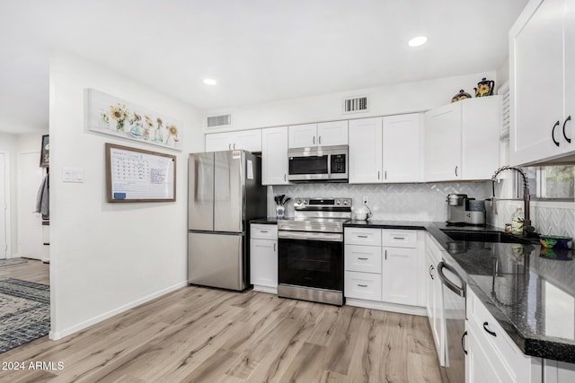 kitchen featuring sink, white cabinetry, stainless steel appliances, and light hardwood / wood-style flooring