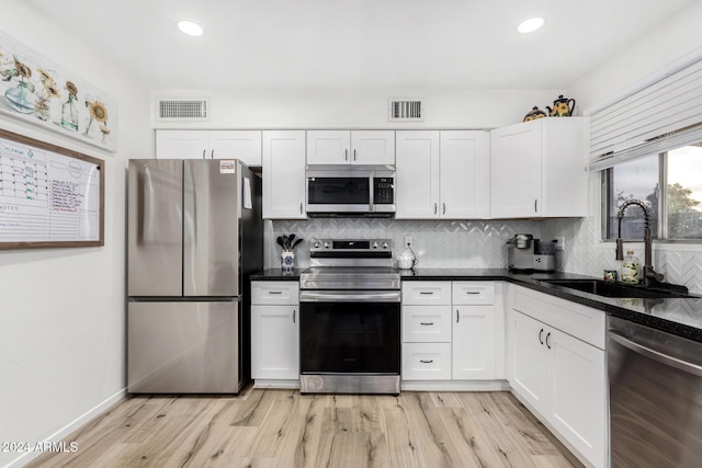 kitchen with sink, white cabinets, and appliances with stainless steel finishes