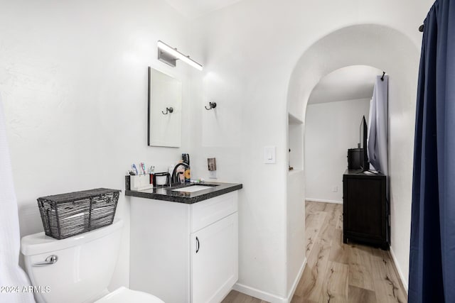 bathroom featuring hardwood / wood-style flooring, vanity, and toilet