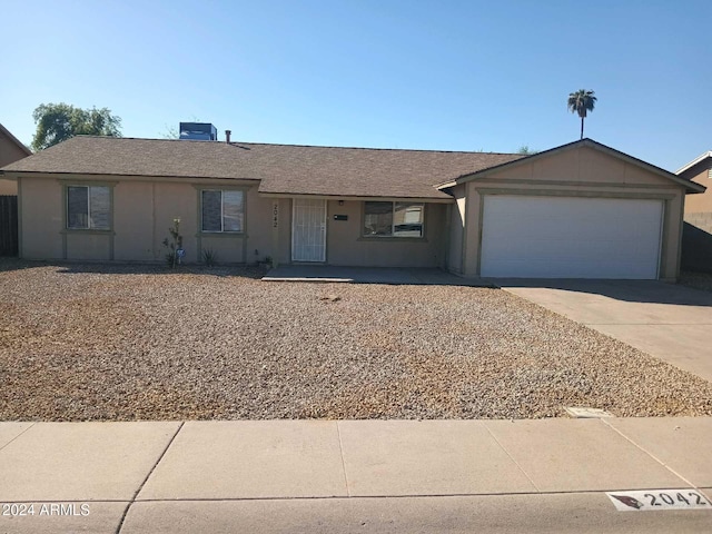 ranch-style house with central AC unit and a garage