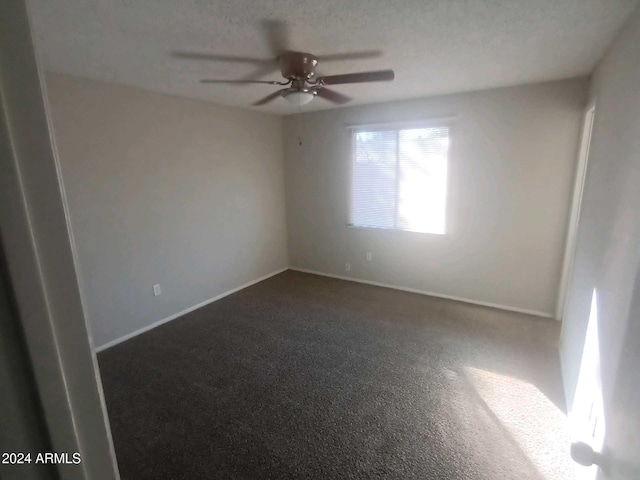 carpeted spare room with ceiling fan and a textured ceiling