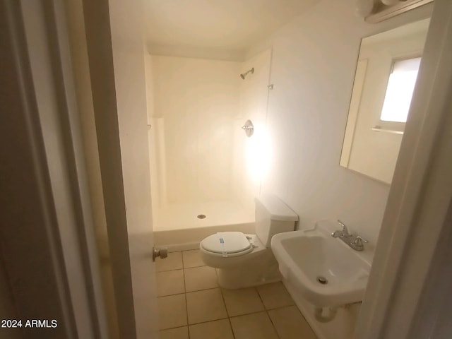 bathroom featuring toilet, walk in shower, sink, and tile patterned flooring