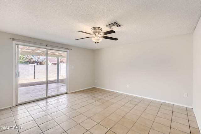 empty room with a textured ceiling, light tile patterned floors, and ceiling fan