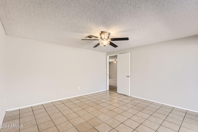 tiled empty room with a textured ceiling and ceiling fan