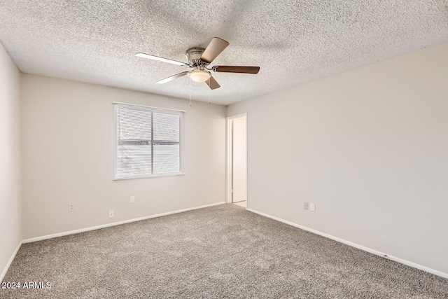 carpeted empty room featuring ceiling fan and a textured ceiling