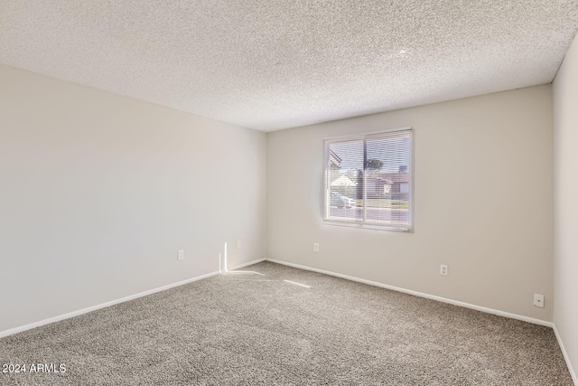 carpeted empty room featuring a textured ceiling