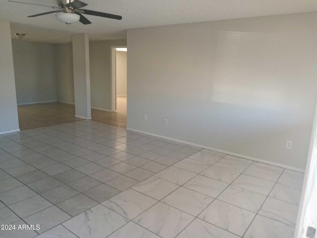 empty room featuring a textured ceiling and ceiling fan