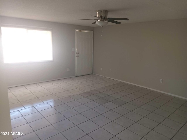 tiled empty room with ceiling fan