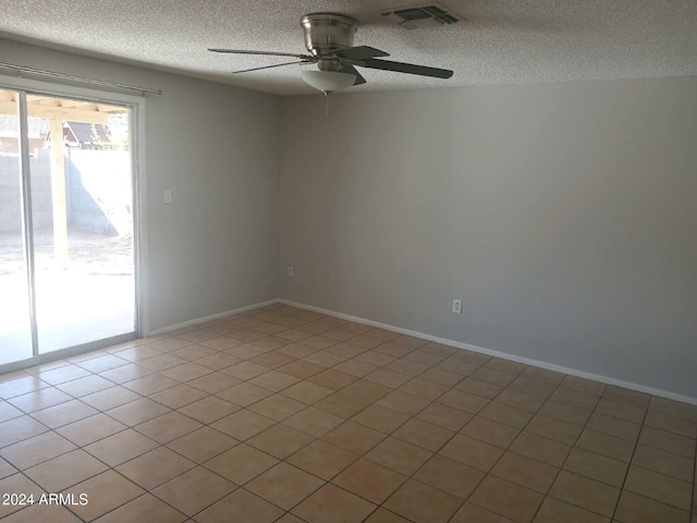 empty room with ceiling fan, a textured ceiling, and light tile patterned flooring