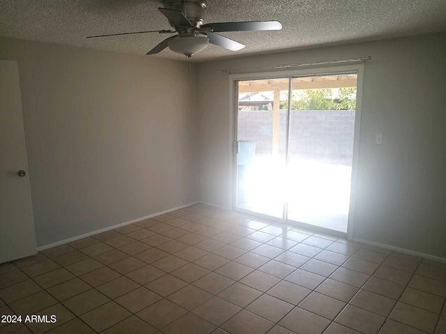 tiled spare room featuring a textured ceiling and ceiling fan