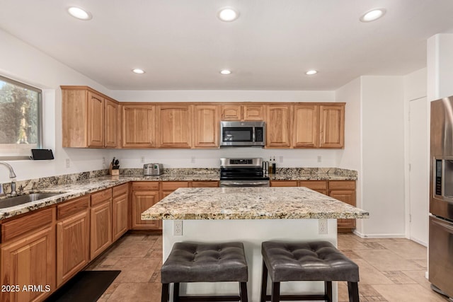 kitchen featuring a breakfast bar, sink, stainless steel appliances, and a center island