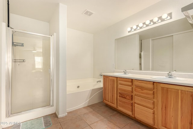 bathroom with tile patterned flooring, vanity, and shower with separate bathtub