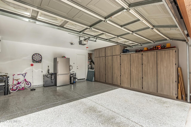 garage featuring a garage door opener and stainless steel refrigerator