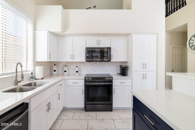 kitchen featuring plenty of natural light, black dishwasher, sink, and range with electric cooktop