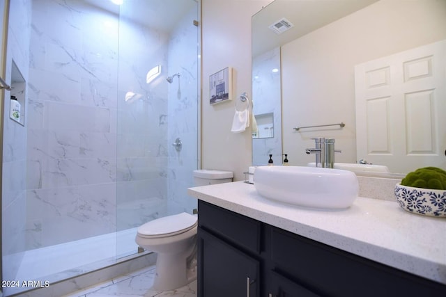 bathroom featuring tiled shower, vanity, and toilet