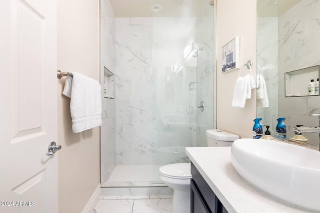 bathroom featuring a tile shower, vanity, and toilet