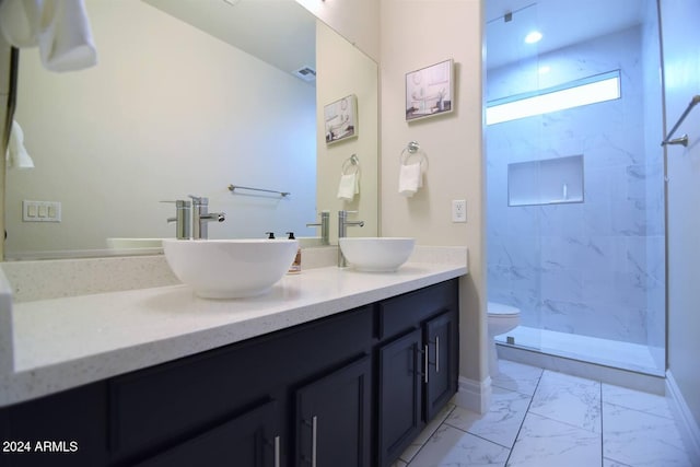 bathroom with tiled shower, vanity, and toilet