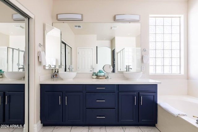 bathroom with vanity and shower with separate bathtub