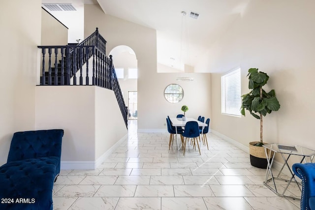 dining area featuring high vaulted ceiling