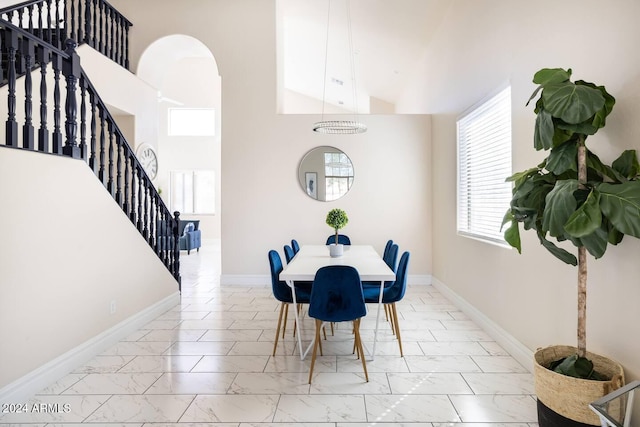 dining space with high vaulted ceiling