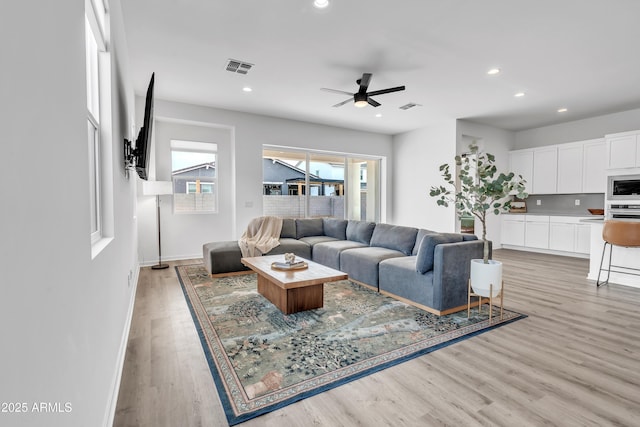 living room featuring ceiling fan and light wood-type flooring