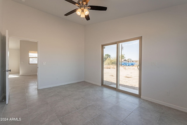 tiled empty room featuring ceiling fan and a wealth of natural light