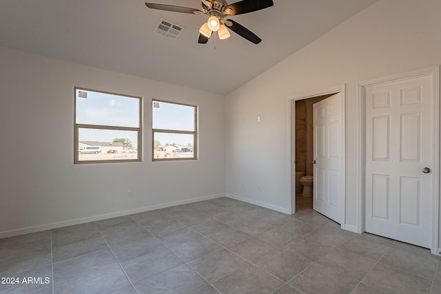 unfurnished bedroom with connected bathroom, vaulted ceiling, ceiling fan, and light tile patterned flooring