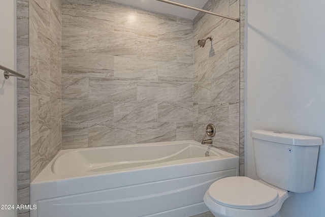 bathroom with tiled shower / bath combo and toilet