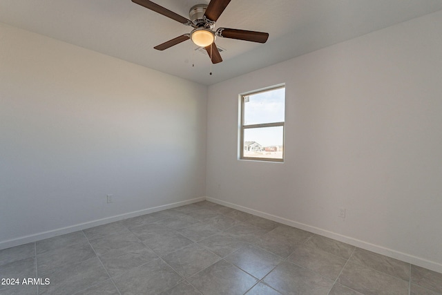 tiled spare room with ceiling fan