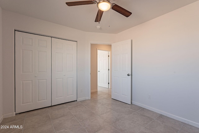 unfurnished bedroom with ceiling fan, a closet, and light tile patterned floors