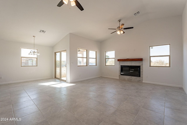 unfurnished living room with ceiling fan with notable chandelier, vaulted ceiling, and plenty of natural light