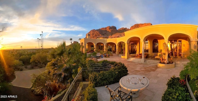 back house at dusk with a patio