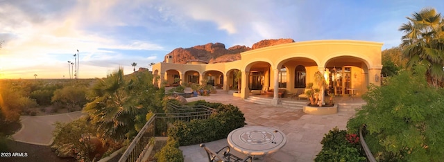 back house at dusk with a patio