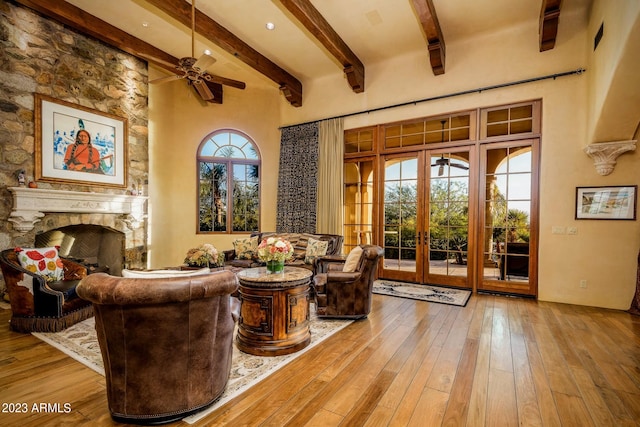 living room with beam ceiling, french doors, a healthy amount of sunlight, and light hardwood / wood-style flooring