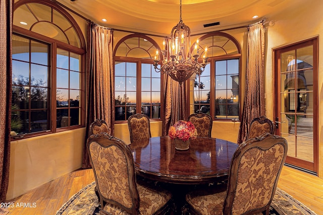 dining room with a notable chandelier, light hardwood / wood-style floors, and ornamental molding