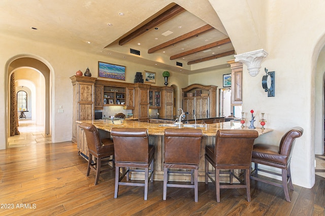 kitchen featuring dark hardwood / wood-style floors, kitchen peninsula, and a breakfast bar