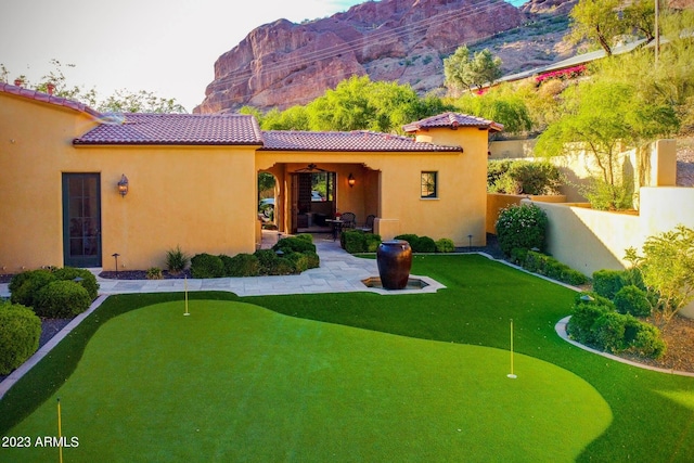 back of house featuring a patio area, a mountain view, and ceiling fan