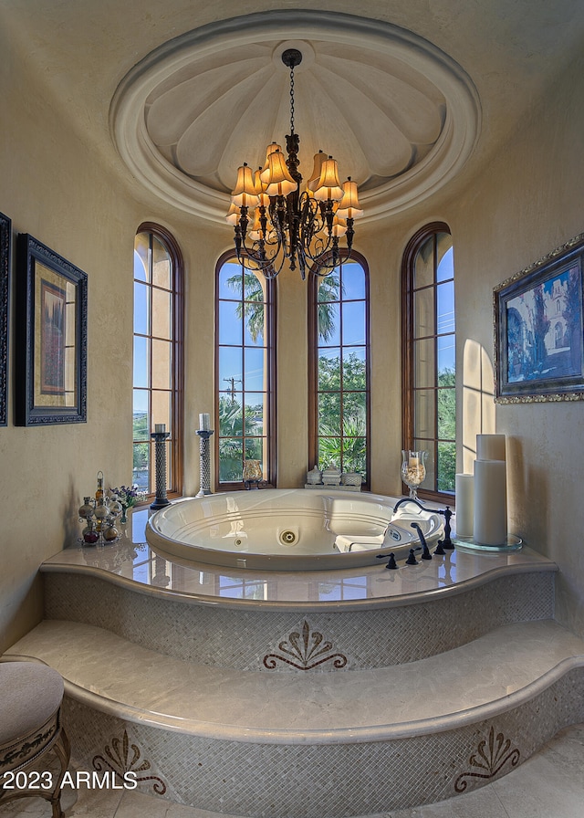 bathroom with a bath, a raised ceiling, and a notable chandelier