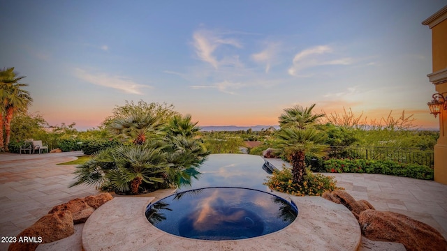 yard at dusk featuring a patio