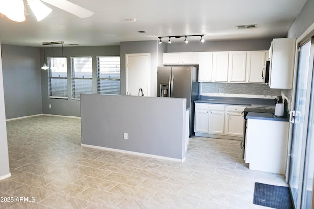 kitchen with stainless steel fridge, tasteful backsplash, ceiling fan, white cabinetry, and hanging light fixtures