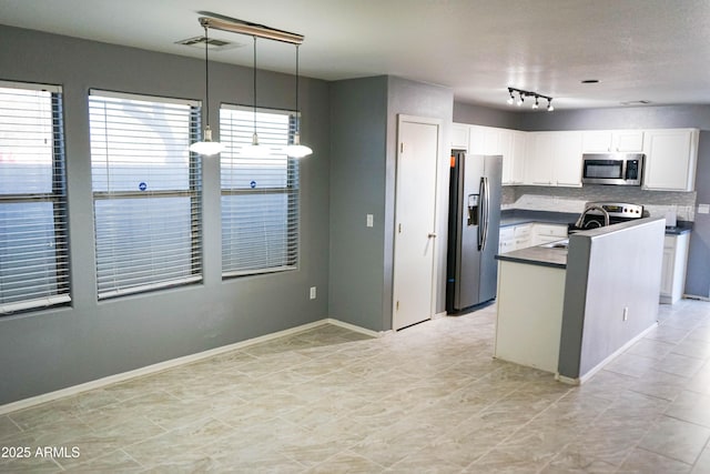 kitchen with white cabinetry, sink, stainless steel appliances, tasteful backsplash, and decorative light fixtures