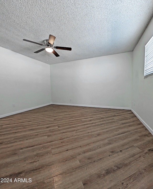 unfurnished room featuring a textured ceiling, ceiling fan, and dark wood-type flooring