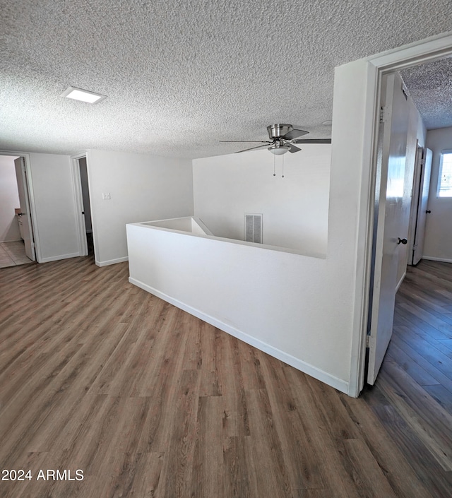 interior space featuring hardwood / wood-style floors, a textured ceiling, and ceiling fan